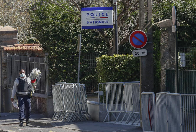 Un policier porte des fleurs vers le commissariat où une agente administrative a été mortellement poignardée, le 24 avril à Rambouillet.