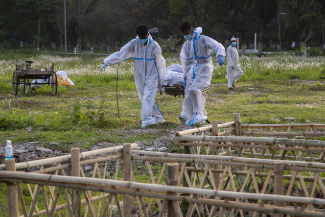 Des agents municipaux préparent l’enterrement d’un mort du Covid-19 à Gauhati, en Inde, le 25 avril.