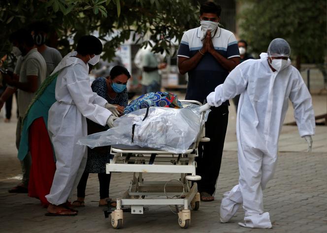 Le corps d’un patient mort du Covid-19 est emporté par des infirmiers, à Ahmedabad, en Inde, le 26 avril.