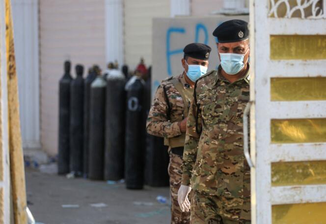 Des policiers irakiens se tiennent à la porte de l’hôpital Ibn Al-Khatib de Bagdad, le 25 avril 2021, après qu’un incendie a éclaté dans l’établissement médical.