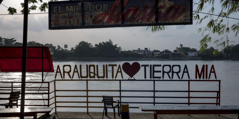 Arauquita, Colombia, 25 avril 2021: Depuis la rive colombienne, on distingue un drapeau aux couleurs vénézuéliennes peint sur l'autre rive. La rivière Arauca sert de frontière entre la Colombie et le Vénézuéla. 
Au total, environ 5 800 personnes ont été enregistrées comme réfugiés à Arauquita et dans ses environs. Les réfugiés ont fui les combats entre l'armée vénézuélienne et les groupes dissidents de la guérilla des FARC-EP qui ont débuté le 20 mars 2021 dans la région d'Apure au Venezuela. Crédit: Nadège Mazars pour Le Monde