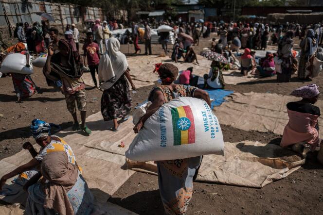 Une femme porte un sac de blé après une distribution de nourriture à Alamata en Ethiopie, le 11 décembre 2020.