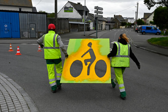Des employés municipaux utilisent des pochoirs pour marquer une ligne de circulation de vélos sur une route à Saint-Malo (Bretagne), le 11 mai 2020.