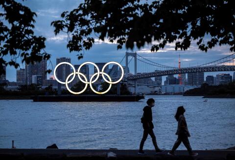 (FILES) This file photograph taken on April 28, 2021, shows a general view of the Olympic rings lit up at dusk on the Odaiba waterfront in Tokyo. US drugs giant Pfizer and its German partner BioNTech on May 6, 2021, have announced a deal with the International Olympics Committee to provide vaccines to competitors and staff at the Tokyo games. In a statement, the firms said they would coordinate with national sporting bodies to make sure that coronavirus vaccines are available to anyone who needs one before travelling to Japan / AFP / CHARLY TRIBALLEAU 