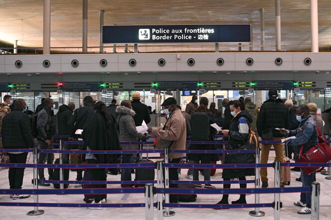 Des voyageurs préparent leurs justificatifs à présenter à la police des frontières, à l’aéroport international Roissy Charles-de-Gaulle, le 1er février 2021.