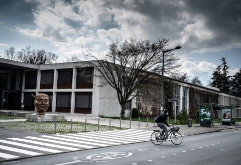 A student cycles past the statue "Hypnos" by Spanish artist Jose Seguiri by the entrance of the Sciences-Po Grenoble's campus, in Saint-Martin-d'Heres, near Grenoble, south eastern France, on March 8, 2021. - After several days of silence, the management of Sciences Po Grenoble, "condemns with the greatest firmness" the accusations of Islamophobia targeting two of its professors who have caused strong reactions during the recent past days. The school recalls in a press released having seized the prosecutor's office of Grenoble which announced on March 6, 2021 the opening of an investigation for "public insult" and "degradation". (Photo by JEAN-PHILIPPE KSIAZEK / AFP) / RESTRICTED TO EDITORIAL USE - MANDATORY MENTION OF THE ARTIST UPON PUBLICATION - TO ILLUSTRATE THE EVENT AS SPECIFIED IN THE CAPTION