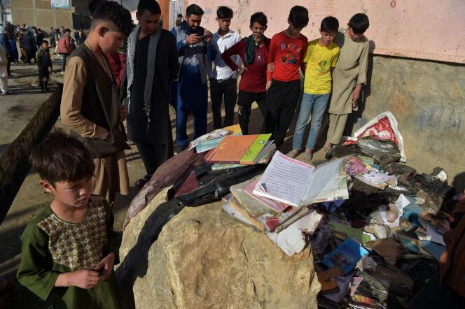 Des élèves regardent les sacs à dos et affaires d’école des victimes de l’attentat d’un lycée de la banlieue de Kaboul, le 9 mai.