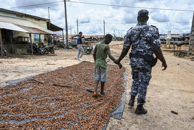 Un policier surprend un enfant en train de sécher du cacao dans le village d’Opouyo, près de Soubré, le 7 mai 2021, lors de l’opération Nawa 2.