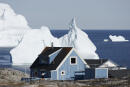Maison de bois bleue devant des icebergs dans le village de Qeqertarsuaq sur l'Ile de Disko au Groenland.