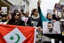 Moroccans hold posters bearing portraits of convicted activists and a flag of the Rif Republic during a demonstration against the court of appeal rulings on Al-Hirak al-Shaabi or "Popular Movement" activists, in the capital Rabat on April 21, 2019. - Human Rights Watch warned Rabat on April 10, 2019 over what it called the "shocking" Moroccan court of appeal rulings against 42 leaders of a protest movement. (Photo by - / AFP)