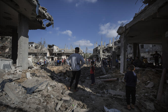 Des Palestiniens dans les décombres de leurs maisons, détruites par des bombardements israéliens, le 14 mai 2021 à Beit Hanoun, dans le nord de la bande de Gaza.