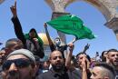 Palestinian Muslim worshippers chant slogans supporting the Islamist movement Hamas flag following Friday prayers in Jerusalem's al-Aqsa mosque compound, the third holiest site of Islam, on May 14, 2021. / AFP / ahmad gharabli
