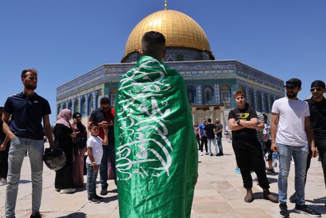 Des fidèles musulmans palestiniens scandent des slogans soutenant le drapeau du mouvement islamiste Hamas, après la prière du vendredi dans l’enceinte de la mosquée al-Aqsa à Jérusalem, troisième site le plus sacré de l’islam, le 14 mai 2021.