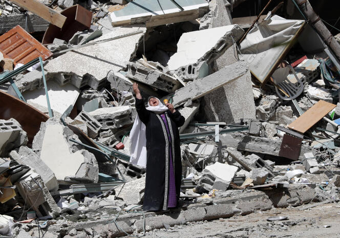 Une femme devant les ruines d’un immeuble détruit lors de l’attaque aérienne israélienne à Gaza, le 16 mai 2021.