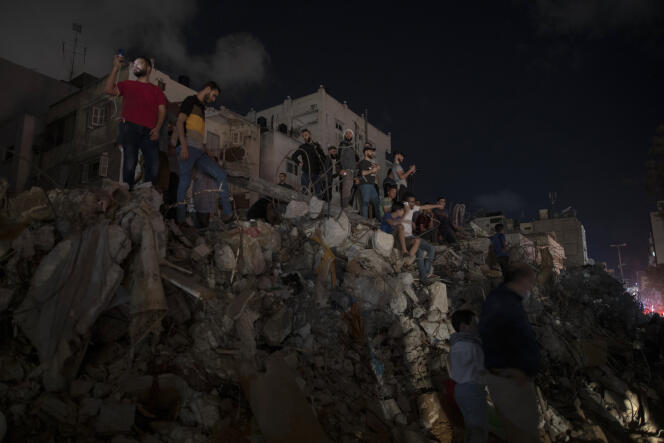Des Palestiniens se tiennent sur les décombres alors que le cessez-le-feu vient d’être déclaré entre Israël et le Hamas, à Gaza, le 21 mai 2021.