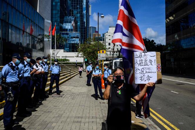 Alexandra Wong macha brytyjską flagą przed sądem w Hongkongu 28 maja 2021 r., Gdy dziewięciu działaczy prodemokratycznych czeka na werdykt pod zarzutem nieuprawnionego gromadzenia się w Święto Narodowe Chin, 1 października 2019 r.