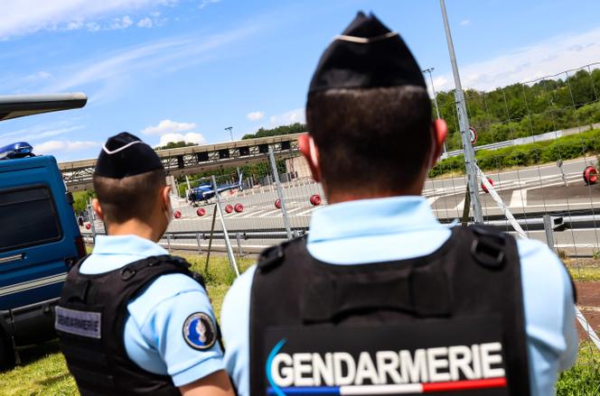 Des gendarmes regardent un hélicoptère stationné sur l’autoroute A89 pendant la chasse à l’homme de l’ancien militaire, Terry Dupin, près de Le Lardin-Saint-Lazare, dans le sud-ouest de la France, le 30 mai 2021.