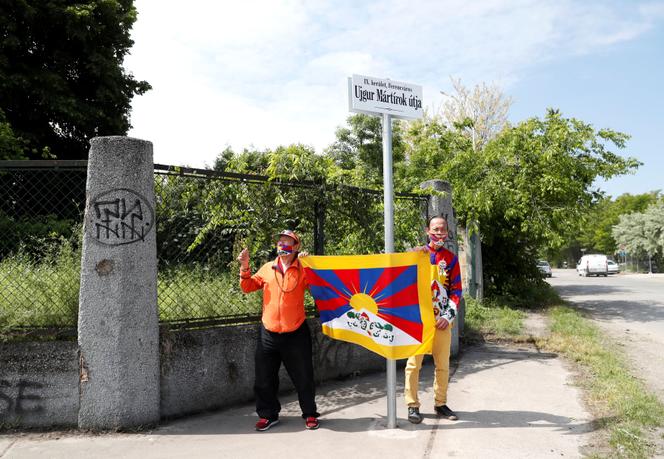 Des militants tiennent un drapeau tibétain devant une rue rebaptisée « Avenue des martyrs ouïgours » à Budapest, le 2 juin 2021.