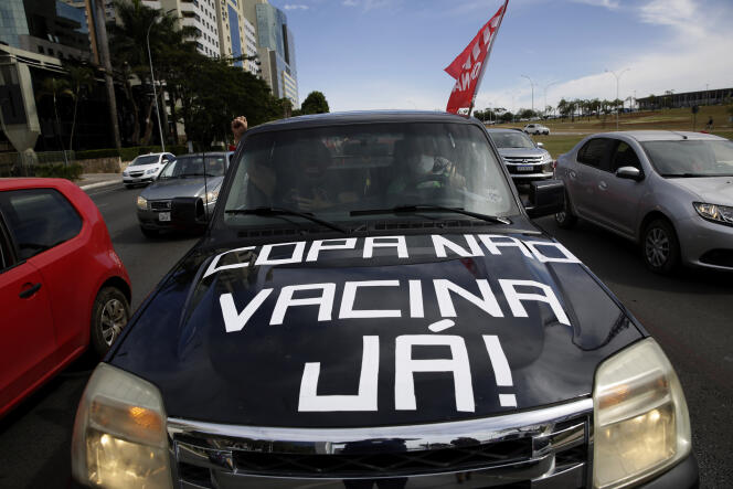 Des manifestants à la tenue de la Copa America au Brésil arborent un slogan inscrit en portugais sur leur voiture : « Copa non, vaccins maintenant », dimanche 6 juin 2021, à Brasilia.