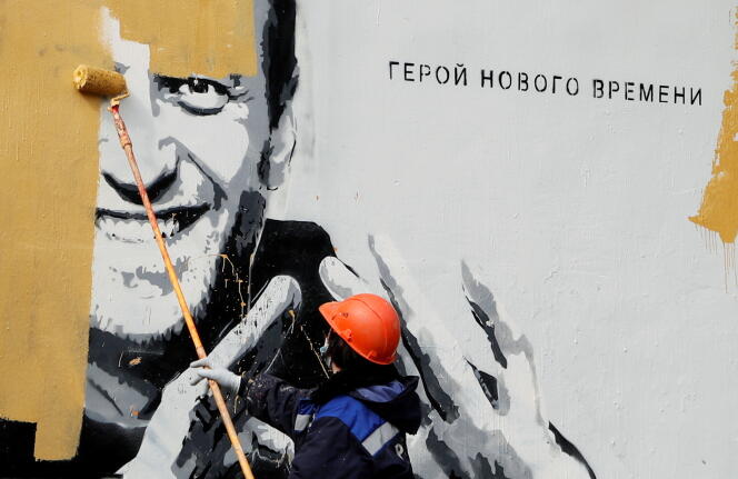Un ouvrier repeint un portrait de l’opposant Alexeï Navalny à Saint-Pétersbourg, en Russie, le 28 avril. A côté du portrait, on peut lire : « Le héros d’une nouvelle époque. »