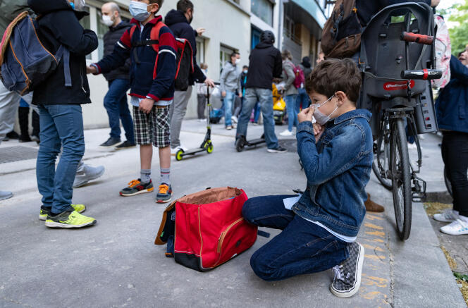 Un garçon ajuste son masque avant d’entrer dans son école primaire, à Paris, le 26 avril 2021.