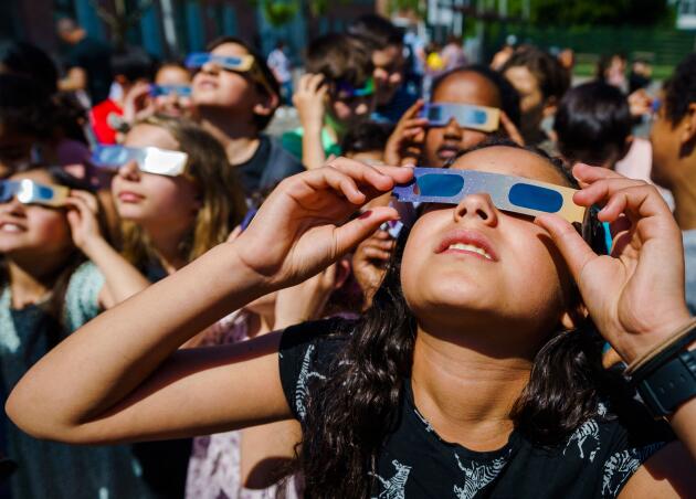 Des enfants observent l’éclipse partielle à Schiedam aux Pays-Bas, le 10 juin 2021.