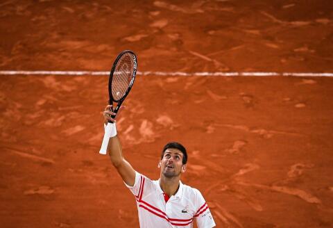 TOPSHOT - Serbia's Novak Djokovic celebrates after winning against Spain's Rafael Nadal at the end of their men's singles semi-final tennis match on Day 13 of The Roland Garros 2021 French Open tennis tournament in Paris on June 11, 2021. / AFP / Christophe ARCHAMBAULT 