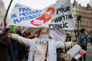 A demonstrator holds a placard reading 'no placebo measures for the public hospital', during a nationwide strike of healthcare workers, in front of the Health Ministry in Paris, on January 21, 2021, to demand better conditions, more hospital beds and wage increases. (Photo by THOMAS COEX / AFP)
