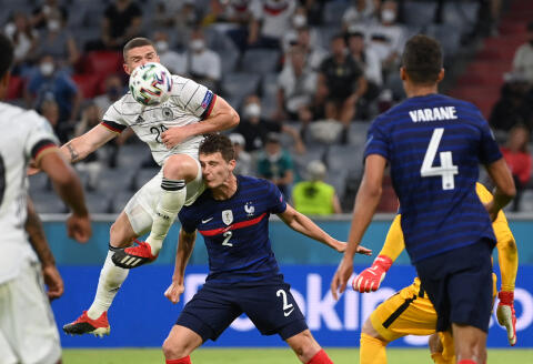TOPSHOT - Germany's defender Robin Gosens (L) collides with France's defender Benjamin Pavard (C) during the UEFA EURO 2020 Group F football match between France and Germany at the Allianz Arena in Munich on June 15, 2021. / AFP / POOL / Matthias Hangst 