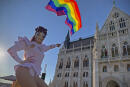 A drag queen waves a rainbow flag during an LGBT rights demonstration in front of the Hungarian Parliament building in Budapest, Hungary on June. 14, 2021. During the protest human rights activists called on lawmakers in Hungary to reject legislation banning any content portraying or promoting homosexuality or sex reassignment to anyone under 18. The bills, aiming at fighting pedophilia, have various amendments which would outlaw any depiction or discussion of different gender identities to youth in the public sphere. (AP Photo/Bela Szandelszky)