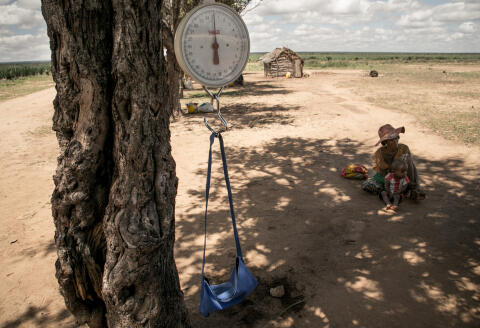 A baby scale is hung on a tree branch during a malnutrition screening session in the municipality of Ifotaka, in southern Madagascar, on December 14, 2018. - In the village of Ifotaka, at the southern tip of Madagascar, the noise and excitement of the country's election campaign seems far away as locals confront more pressing needs in a daily struggle for food. For several seasons now, the entire southern part of Madagascar has been caught up in a drought that has made water increasingly scarce, wrecking even efforts to grow rice -- the staple food. (Photo by RIJASOLO / AFP)