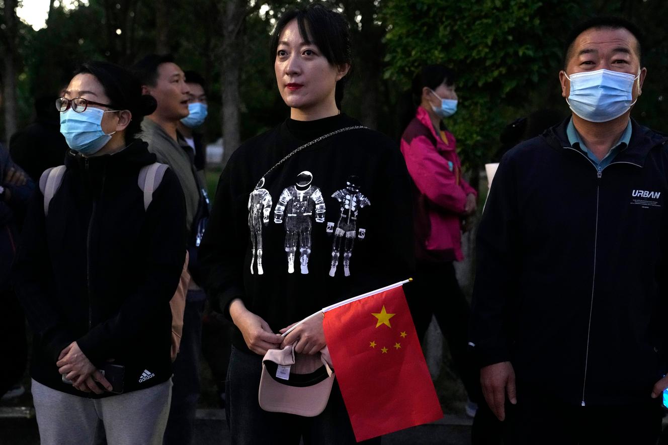 On Thursday, June 17, 2021, an astronaut wearing a space-themed shirt and holding the Chinese flag waits for Chinese astronauts to arrive at the Jiuquan Satellite Launch Center in Juan, northwest China, ready to board the liftoff. Three astronauts aboard the Shenzhou-12 spacecraft, which will be the first crew members to live in Tianhe or Heavenly Harmony, China's new orbital space station. (AP Photo / Ng Han Quan)