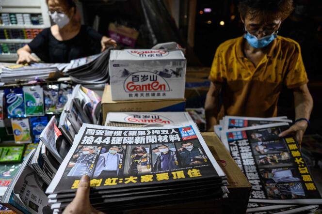 Les employés d’un kiosque à journaux trient les exemplaires du quotidien « Apple Daily », à Hongkong, tôt le 18 juin 2021.