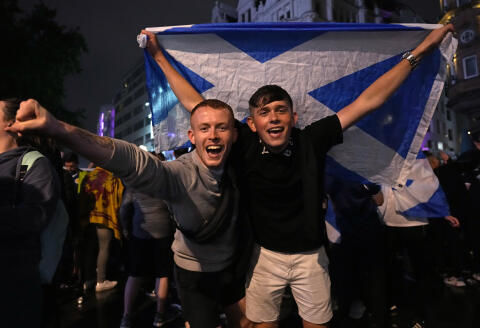 Scotland supporters react in Leicester Square in London, Friday, June 18, 2021 after the Euro 2020 soccer championship group D match between England and Scotland at Wembley Stadium. The match ended in a 0-0 draw. (AP Photo/Kirsty Wigglesworth)