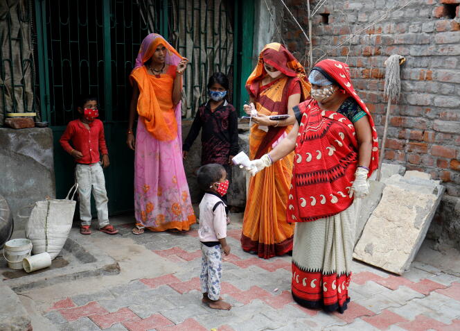 Du personnel de santé prend la température d’un enfant, à Ahmedabad (Inde), le 9 juin 2021.