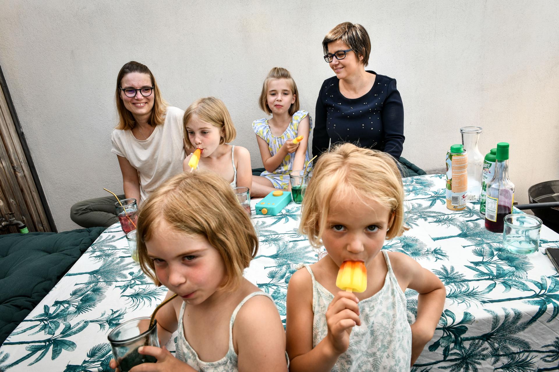 Juliette (9 ans) et les triplées Apolline, Emma et Camille (6 ans) posent alors qu’elles prennent le goûter avec leurs mères Aude et Constance Démettre, sur la terrasse de l’appartement qu’elles habitent à Bordeaux. A Bordeaux le 25 juin 2021.