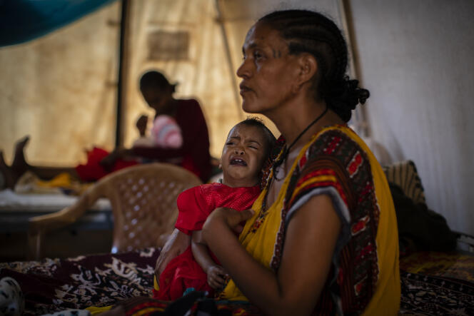 Roman Kidanemariam, 35 ans, tient sa fillette de 22 mois qui souffre de malnutrition, le 11 mai 2021 dans une clinique d’Abi Adi, dans la région du Tigré, en Ethiopie.
