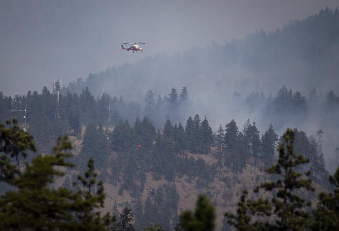 Een helikopterpiloot bereidt zich voor om op 2 juli 2021 water te laten vallen op een bosbrand in Lytton, British Columbia, Canada.