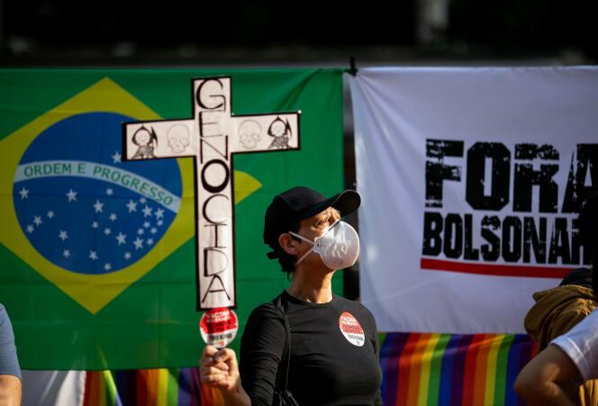 Une manifestante tient un panneau dénonçant un « génocide », lors d’une marche contre le président Jair Bolsonaro, à Sao Paulo (Brésil), le 3 juillet 2021.
