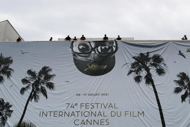 Installation de la toile géante de l’affiche officielle mettant en scène Spike Lee sur la façade du palais des Festivals à Cannes, le 4 juillet 2021.