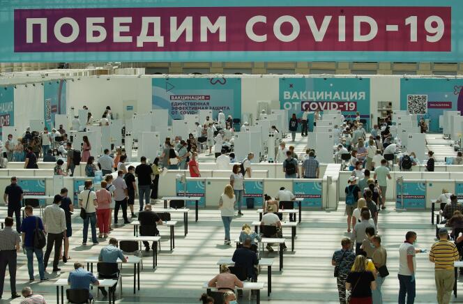 Des dizaines de personnes attendent de recevoir leur vaccin dans le centre de vaccination de Gostiny Dvor, à Moscou, le 6 juillet 2021. Sur la bannière est écrit : « Battons le Covid-19 ».