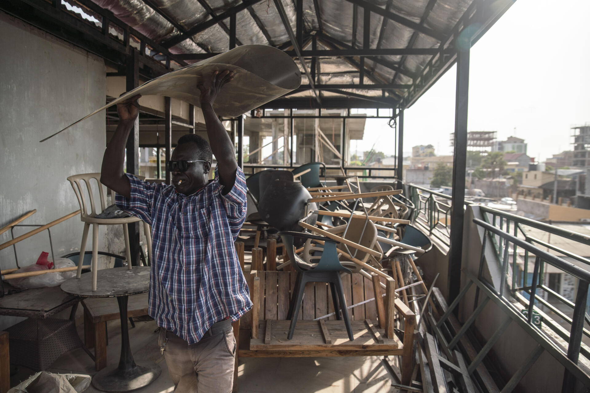 Un ouvrier sud-soudanais reconstruit le toit d'un hôtel pour son propriétaire érythréen, à Juba, le 26 juin 2021.