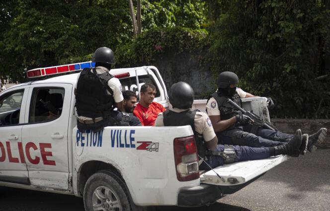 Un véhicule de la police transporte deux suspects menottés et encadrés par des policiers, jeudi 8 juillet, à Port-au-Prince.