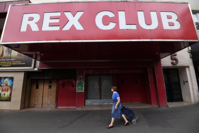 Una mujer atraviesa las puertas cerradas del Rex el 2 de julio de 2020 en París.  Al igual que este histórico centro cultural en el centro de la capital, la mayoría de los clubes de música electrónica no volverán a abrir este verano.