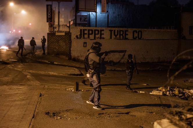 Des agents de sécurité privée lors d’une opération conjointe avec des policiers sud-africains à Jeppestown, en banlieue de Johannesburg (Afrique du Sud), lors d’affrontements avec des résidents, le 12 juillet 2021.