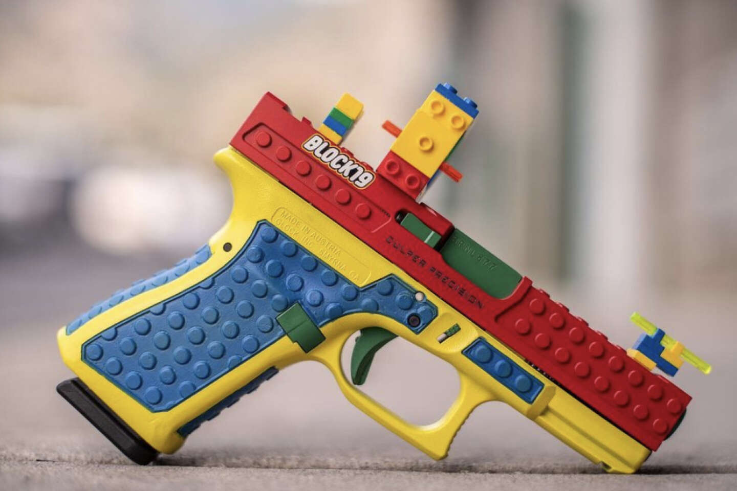 Un Pistolet Lego Est Sur Une Table Avec Un Bâtiment Lego En