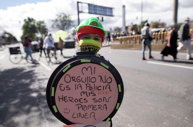 Un enfant tient un bouclier arborant « Ma fierté n’est pas la police, mes héros sont en première ligne », lors de la Fête de l’indépendance de la Colombie, à Bogota, le 20 juillet 2021.