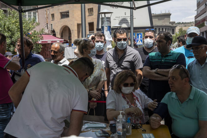 Des iraniens attendent pour se faire vacciner devant une clinique mobile d’Erevan en Arménie, le 7 juillet 2021.