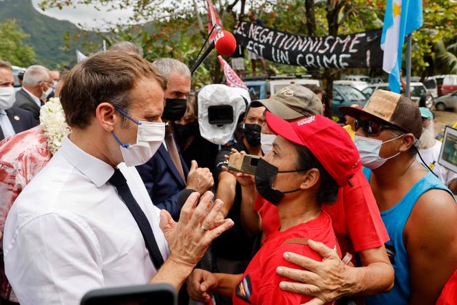 Le président Emmanuel Macron discute avec une victime d’un essai nucléaire qui participe à une manifestation, à son arrivée sur l’île de Moorea, le 27 juillet 2021.