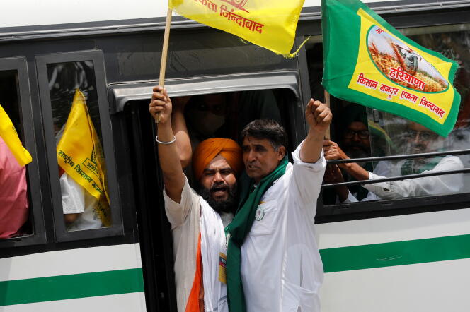Des agriculteurs crient des slogans alors qu’ils arrivent dans un bus pour assister à un sit-in de protestation contre les lois agricoles, près du parlement, à New Delhi, en Inde, le 22 juillet 2021.